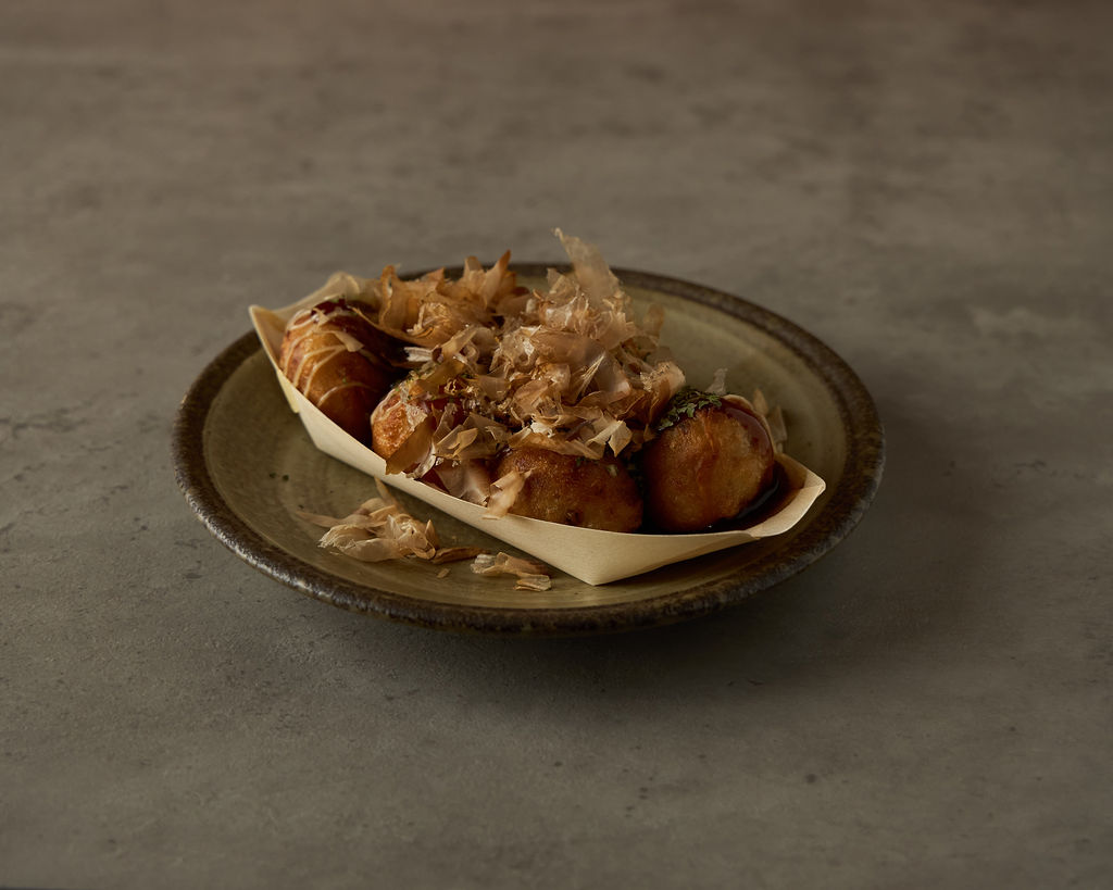 Takoyaki octopus balls in a wooden boat with dancing bonito flakes